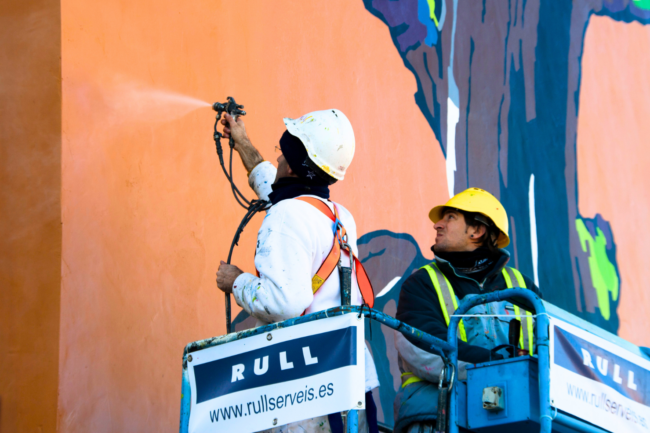 dos trabajadores de rull services haciendo el mantenimiento profesional de pintura en la fachada exterior de un edificio